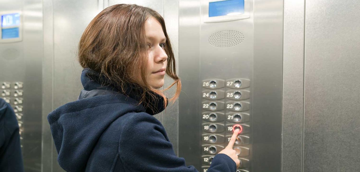 Young teen pushing elevator control